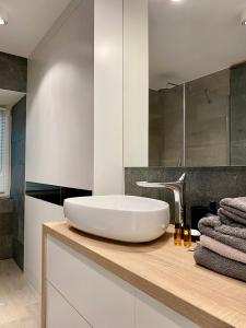 a bathroom with a white sink and a mirror at Dream Apartments Sopot in Sopot