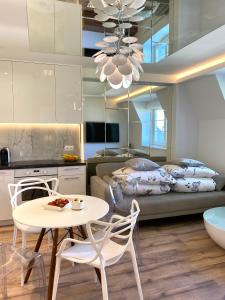 a kitchen and a living room with a table and chairs at Dream Apartments Sopot in Sopot