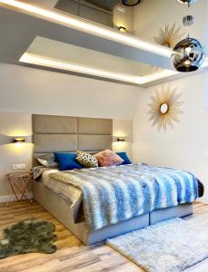 a bedroom with a large bed with a blue blanket at Dream Apartments Sopot in Sopot