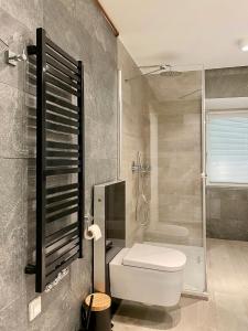 a bathroom with a white toilet and a shower at Dream Apartments Sopot in Sopot