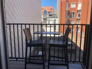 2 stoelen en een tafel op een balkon bij Apartment Mauritius in Knokke-Heist