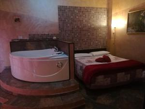 ein Bad mit einer Badewanne und einem Bett in der Unterkunft Villamir B&B in Albenga