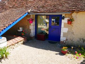 una casa con una puerta azul y una ventana en Au Coeur de la Cour, en Saint-Georges-sur-Cher