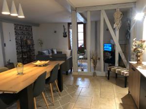 a dining room and living room with a wooden table at La Champenoise in Marson
