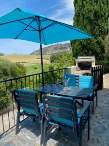 une table et des chaises bleues avec un parapluie bleu dans l'établissement Campo d'elge, à Patrimonio