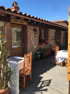 un restaurante con mesa y sillas frente a un edificio en Posada La Herradura, en Liermo