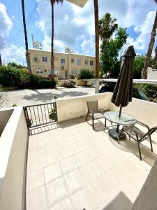 a patio with a table and a chair and an umbrella at (L.I.H.8) Luxury Industrial House 8 in Nea Paphos