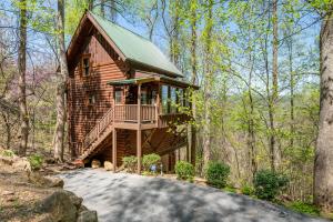 a log cabin in the woods with a balcony at Dancing Dragonfly 26 in Sevierville