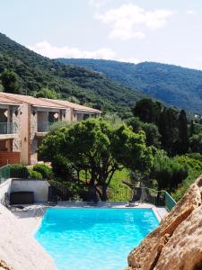 a large blue swimming pool in front of a house at Residence Roc E Mare Cargèse in Cargèse