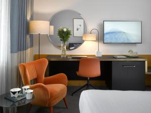 a hotel room with a desk and a chair at K+K Hotel Fenix in Prague
