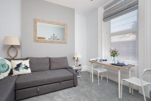 a living room with a couch and a table at Stopover at SEABIRD APARTMENTS central Southsea in Portsmouth