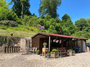 ein kleines Gebäude mit einem Tisch und Stühlen in der Unterkunft Hotel Pension Gelpkes Mühle in Bad Sachsa