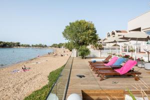 a beach with chairs and umbrellas and people on it at Domus Aqua in Kato Daratso