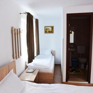 a bedroom with two beds and a door to a bathroom at Casa Pedro in Blăjani