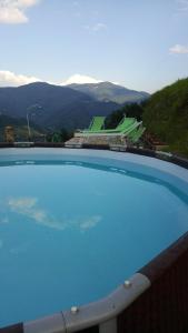 una gran piscina azul con montañas en el fondo en Casa Millin en Borzonasca