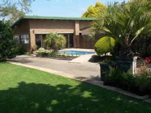 a house with a swimming pool in a yard at Rita's Guesthouse CC in Vryheid