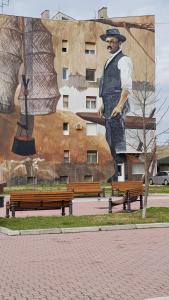 a large mural of a man in a hat on a building at CityS in Apatin