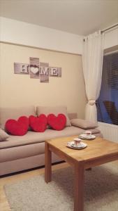 ein Wohnzimmer mit einem Sofa mit roten Kissen darauf in der Unterkunft Ferienwohnung Herzblatt in Willingen