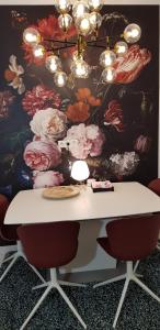 uma mesa com cadeiras em frente a uma parede com flores em In Den Visser em Dordrecht