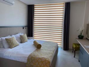 a bedroom with a bed with a large window at Zest Exclusive Hotel & Spa in Ortakent