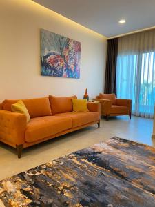a living room with an orange couch and a rug at Zest Exclusive Hotel & Spa in Ortakent