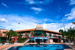 a large building with a swimming pool in front of it at Oscar Inn Eco Resort in Águas de Lindoia