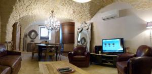 een woonkamer met een bank en een eetkamer bij Clos de Raveyron in Vallon-Pont-dʼArc