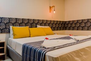 a bedroom with a large bed with yellow and blue sheets at Baía Branca Beach Resort in Tamandaré