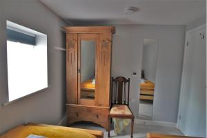 a wooden cabinet in a room with a bed at 1 Fox Studios in Much Wenlock +12 photos