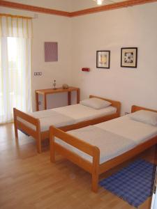 two twin beds in a room with wooden floors at Apartman Roman Mandre in Mandre