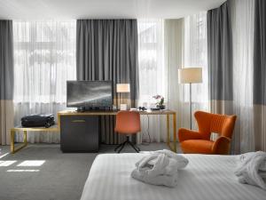 a hotel room with a bed and a desk and a television at K+K Hotel Fenix in Prague