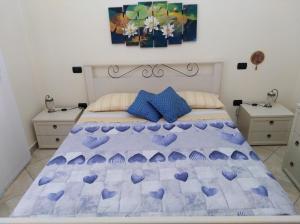 Un dormitorio con una cama con corazones morados. en La dimora delle 4 stagioni, en Barletta