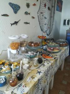 einen Tisch mit einem Tischtuch mit Essen drauf in der Unterkunft Hotel Punta Barone in Santa Marina Salina
