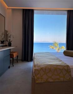 a bedroom with a large window with a view of the ocean at Zest Exclusive Hotel & Spa in Ortakent