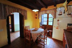 a kitchen with a table and chairs in a room at Casa Rural Los Aromos - Wunderschönes Landhaus mit Meerblick in Hermigua