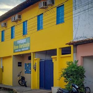 a yellow building with a motorcycle parked in front of it at Pousada Novo Horizonte in Barreirinhas