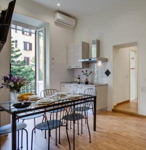 una cucina e una sala da pranzo con tavolo e sedie di Otium Maecenatis Apartments a Roma