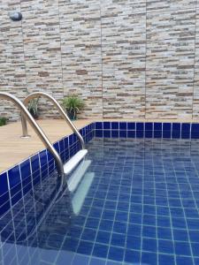 basen z niebieską podłogą wyłożoną kafelkami i schodami w obiekcie casa em salinopolis w mieście Salinópolis