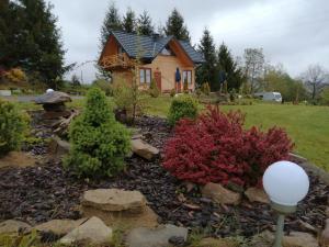 a small house with a garden in front of it at Chrząszczewo Widokowe Wzgórze in Uherce Mineralne