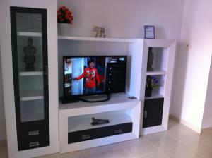 einen TV in einem weißen Entertainment-Center in der Unterkunft Casa Ibiza in Los Alcázares