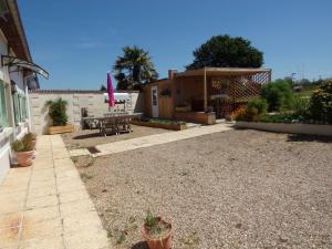 a backyard with a house with a table and a patio at La ciboulette in Les Loges +10 photos