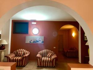 2 Stühle in einem Wohnzimmer mit Torbogen in der Unterkunft Villa Zagara in Gioiosa Ionica