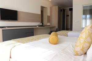 a hotel room with two beds with a yellow hat on the bed at Zest Exclusive Hotel & Spa in Ortakent