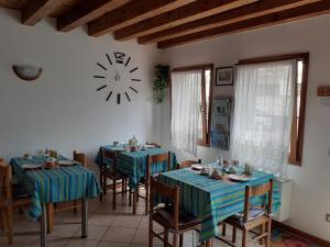 een eetkamer met twee tafels en een klok aan de muur bij B&B Casa Taty in Dolo