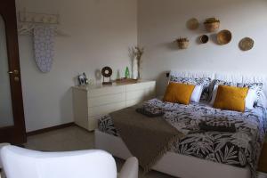 a bedroom with a bed with yellow pillows and a chair at Casa all'era in Cernobbio