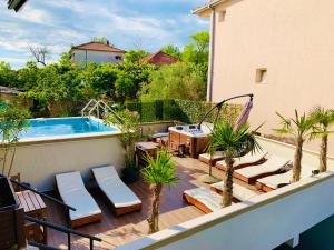a balcony with a swimming pool and a patio with palm trees at Apartments Tati in Ulcinj