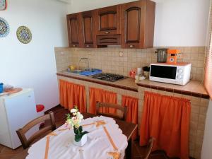 cocina con mesa y microondas en Casa Vacanza Za' Giuvannina en Sciacca