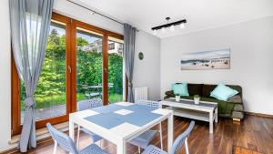a living room with a table and chairs and a couch at Aquarius Sopot - BillBerry Apartments in Sopot