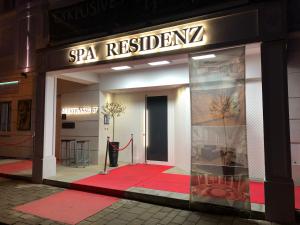 un negozio con un tappeto rosso davanti di 25h SPA-Residenz POOLs IN & OUT, private Garden & Beach a Neusiedl am See