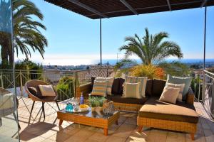 a patio with a couch and a table on a balcony at Villa Sitges Loto Amazing View Confortable AC 20 minutes walk Sitges beaches in Sitges